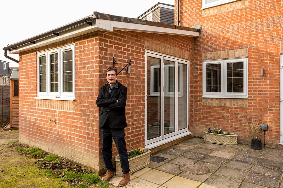 Horsham architect, Luigi Del Vecchio Leaning against a newly built rear extension that he has designed.