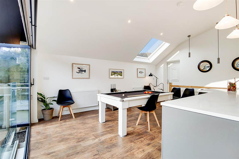 A newly built garden building showing a a dining table that converts to a pool table.