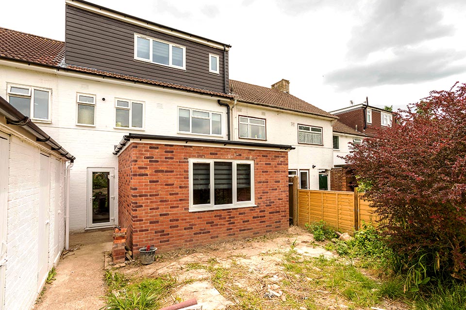 Exterior shot of a terrace building with a recent loft conversion and newly built rear extension.