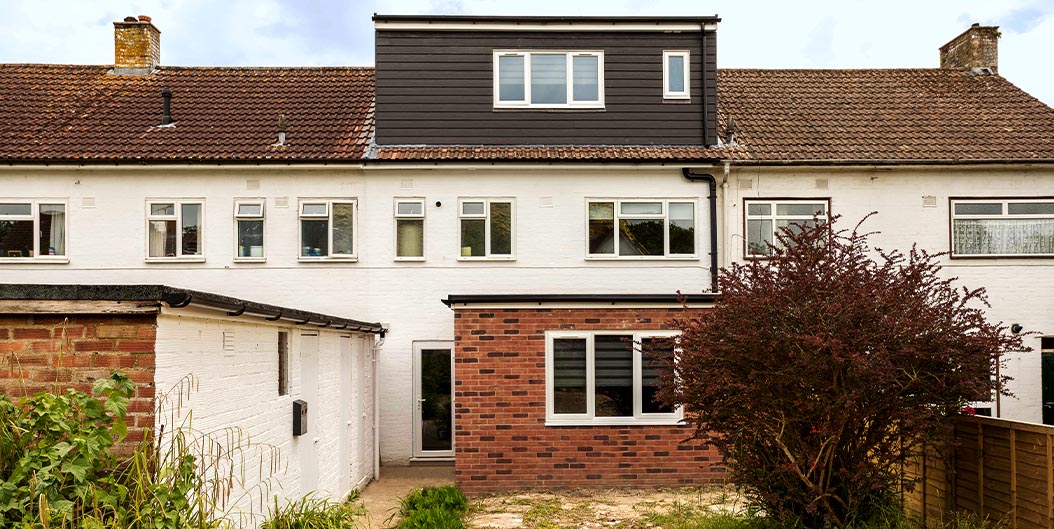 Exterior shot of a terrace building with a recent loft conversion and newly built rear extension.