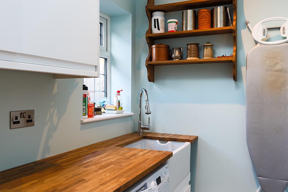 A utility room with a wooden worktop and a butler sink.