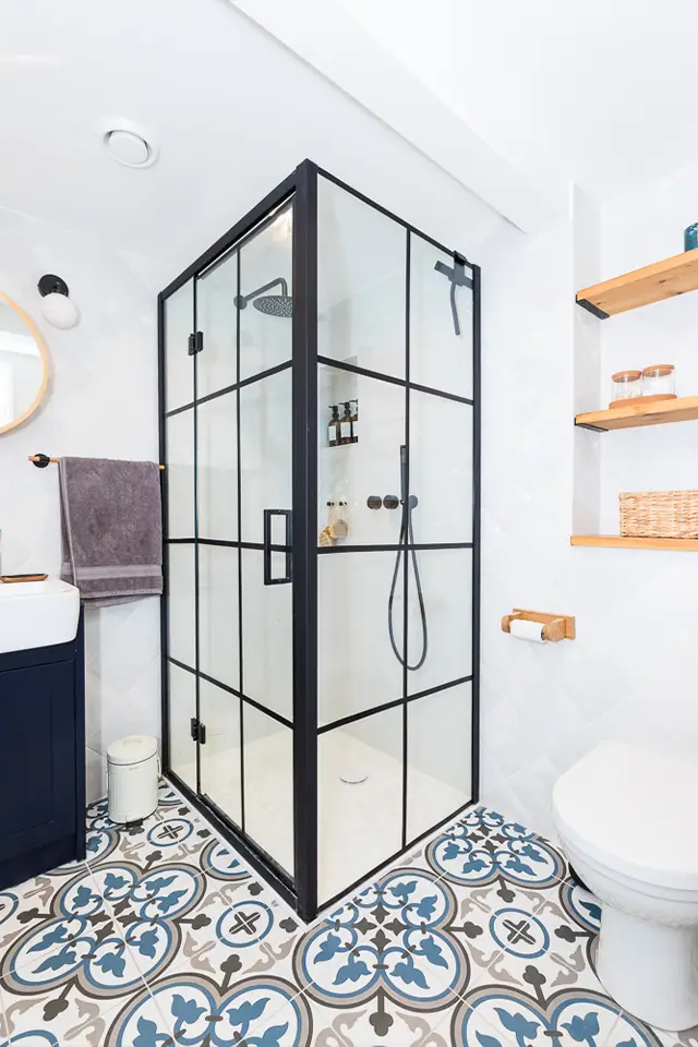 A floor to ceiling shower cubicle with black framing in a newly refurbished bathroom.