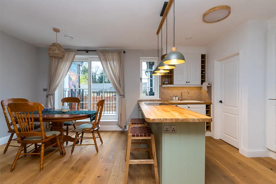An open-plan kitchen / diner space with wooden floors in a 1st floor flat.